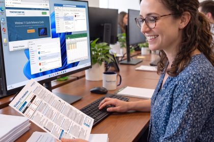 An office employee using a TeachUcomp Quick Reference Guide.