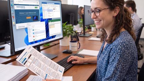 an-employee-using-quick-reference-guide An office employee using a TeachUcomp Quick Reference Guide.