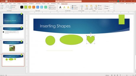 A picture of a user inserting shapes in PowerPoint. The user is inserting a heart shape with a default size.
