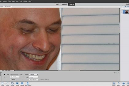A picture of a user correcting photo imperfections using the Healing Brush Tool in Photoshop Elements.